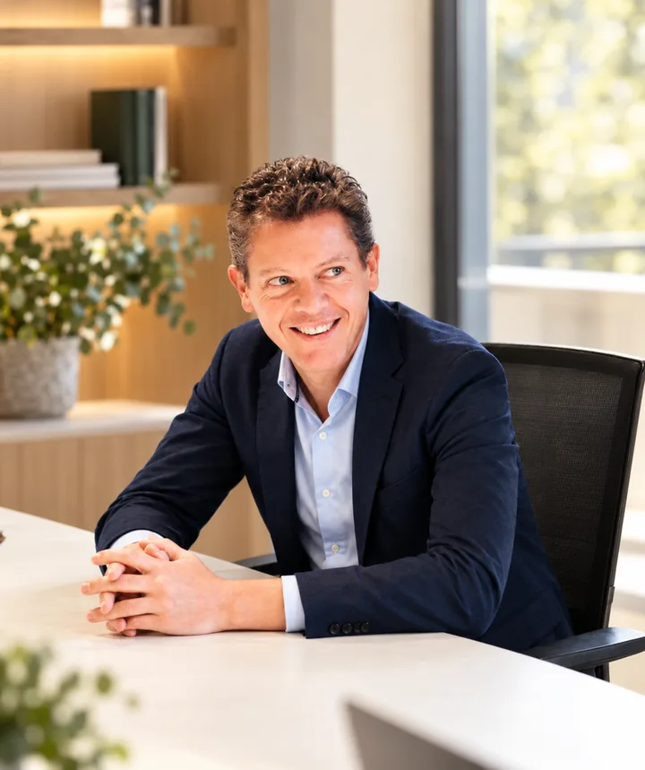 Stefan Peetroons, glimlachend aan een tafel